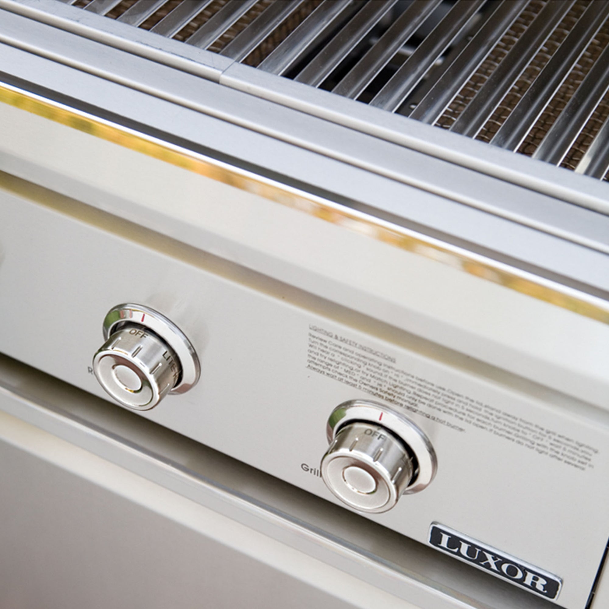Stainless steel grill with two control knobs and 'Luxor' branding.